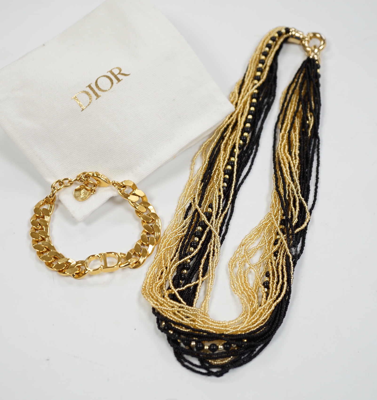 A Christian Dior Danseuse Etoile gilt bracelet, 18cm, with Dior box and pamphlet etc. together with a Luciani Murano glass bead twist necklace, 48cm.